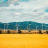 white wind turbines on brown field under blue and white sunny cloudy sky during daytime