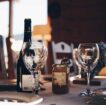 closeup photo of two empty wine glasses beside wine bottle